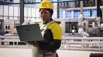 Solar panels factory engineer analyzing data from IoT sensors to refine equipment operational efficiency. Worker performing system diagnostics to reduce downtime in photovoltaic production, camera A video