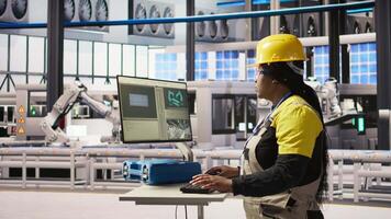 Portrait of cheerful factory engineer typing on PC, overseeing monitoring of production lines. Jolly woman in industry 4.0 plant ensuring machinery operates at optimal efficiency, camera A video
