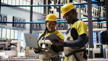 Engineering team working together in industry 4.0 plant to diagnose malfunctions. Teamworking factory colleagues coordinating repair tasks on manufacturing assembly lines, camera A video