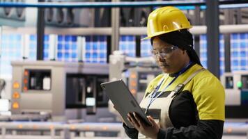 Expert using tablet to conduct routine inspections in industry 4.0 plant producing renewable energy. Photovoltaics smart factory employee testing equipment using device, camera B video