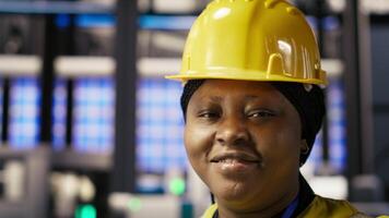 Happy engineer in smart photovoltaics factory looking at system performance metrics. Smiling worker in solar panels plant tracking energy production through IoT sensors, camera B close up video