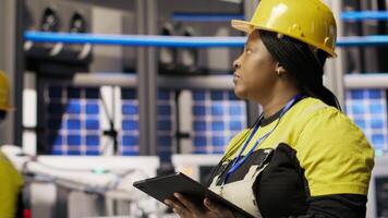 Smart manufacturing factory engineer using tablet app to calibrate high tech machinery and analyze sensor data. Engineer using digital device to troubleshoot photovoltaic assembly equipment, camera B video