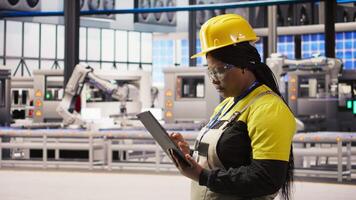 Expert using tablet to conduct routine inspections in industry 4.0 plant producing renewable energy. Photovoltaics smart factory employee testing equipment using device, camera A video