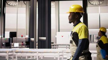 Man walking in industry 4.0 plant, taking note of modifications to make, providing technical support. Smart factory serviceman adding IoT sensors monitoring energy consumption, camera A video