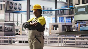 Portrait of jolly smart factory engineer calibrating high tech machinery and analyzing sensor data. Happy industrial plant worker troubleshooting assembly equipment, camera A video