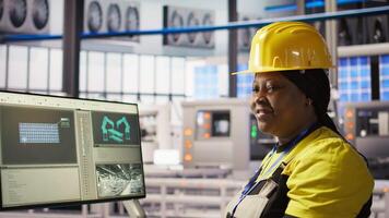 Happy engineer in smart photovoltaics factory looking at system performance metrics. Smiling worker in solar panels plant tracking energy production through IoT sensors, camera A video