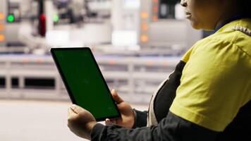 Close up of green screen tablet used by engineer in factory to perform maintenance, analyzing IoT sensors data. Industrial plant worker managing photovoltaic systems using chroma key device, camera B video