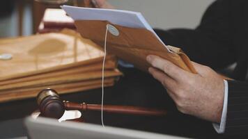 A judge's gavel is used to open a file in a courtroom video