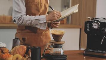 A person in an apron is writing on a notepad video