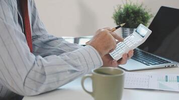 A man is using a calculator to calculate the cost of a project video