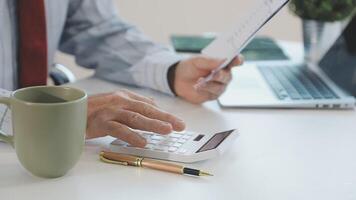 A man is using a calculator to calculate the cost of a business video