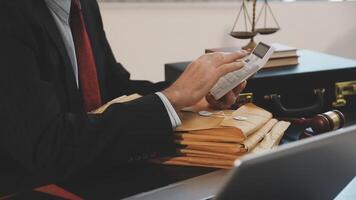 A man in a suit is using a calculator while sitting at a desk video