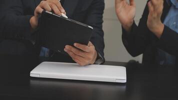 Two people in business attire holding a tablet computer video