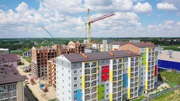 Construction site of a modern district. Tower crane build new high-rise buildings on nature background. Residential complex is building. Drone view. video