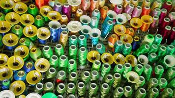 Background of colorful spools.Rows spools of thread of different colors for the sewing machine. Bright colors of threads on the table. video
