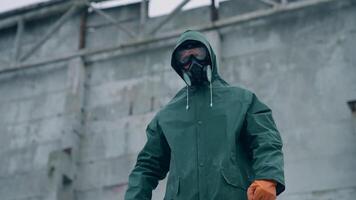 Man in gas mask on destroyed building background. Survivor in respirator and safety suit standing in radioactive zone. Ecological catastrophe. Post apocalyptic world. video