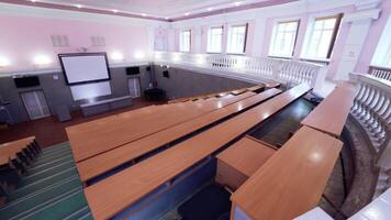 Large conference hall with nobody. Empty auditorium with large white board and rows of desks. Modern classroom for lectures in the university. video