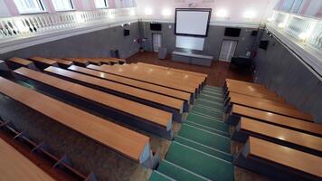 Modern hall for meetings. Large university auditorium with row of desks and a large white board. Empty classroom. video
