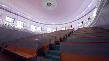 Educational hall with nobody. Empty auditorium with wooden desks. Modern large meeting room with rows of tables and stairs. video