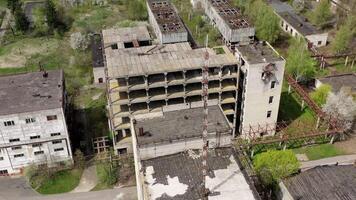 Old industrial edifices. Ancient manufactory with ruined buildings in abandoned zone in springtime. Camera rising up. video