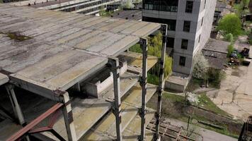 Unfinished building of abandoned factory. Old industrial architecture in spring. Camera rising. Aerial view. video