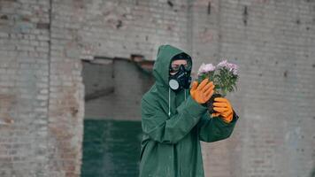 mujer ecologista en la seguridad traje participación muriendo flores humano vistiendo gas máscara y materiales peligrosos disfraz en abandonado edificio. ambiental problemas en contaminado zona. video