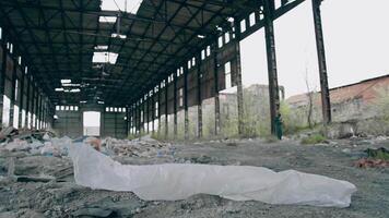 Abandoned building with garbage inside. Scientist in protective uniform in destroyed building. Biological attack. video