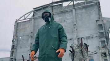 Man wearing hazmat suit in polluted zone. Worker in protective suit, mask and gloves in abandoned place with biological attack threat. video