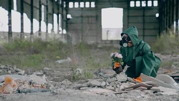 Woman in safety uniform in abandoned place. Scientist in protective suit and respirator with tendy flowers in ruined building. Environment in danger. video