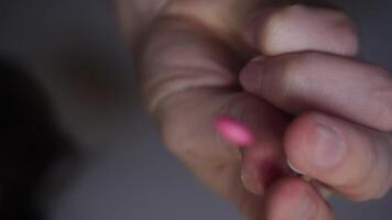 Close-up of human hand is shown, with handful of pills being poured directly onto camera lens. pills are shown in blurry and out-of-focus state. video