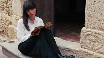 Young Woman Reading An Ancient Book With Passion Sitting On A Building Steps video