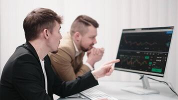 Two analysts observing the development and growth of an interactive chart on the screen. Concept data analysis, monitoring growth video
