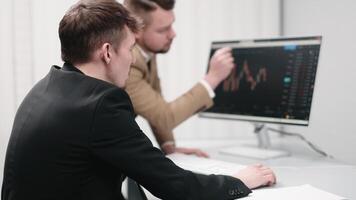 Two analysts observing the development and growth of an interactive chart on the screen. Concept data analysis, monitoring growth, and making decisions for successful investments video
