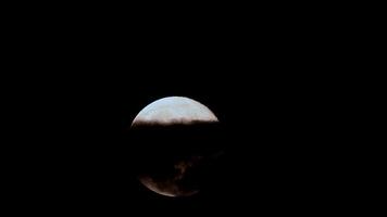 Majestic full moon rises through clouds in a captivating night sky time lapse video