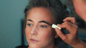 Eye makeup is gently applied in soft light. Shades blend to create depth and allure video