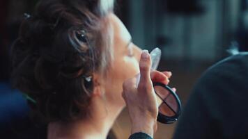 The soft glow of morning light illuminates her beauty routine. A sense of calm fills the frame video
