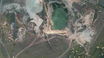 aerial view over an abandoned and flooded quarry. Drone footage of a small rock quarry flooded into a small lake. Aerial view of open cast mine. Turquoise background of the water in open pit. video