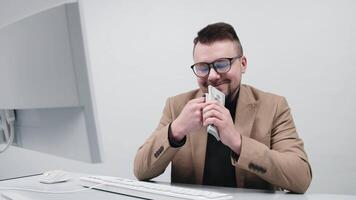 Business man in glasses enjoys a large sum of cash in his hands in a modern office. The concept is to convey the feeling of achieving financial independence video