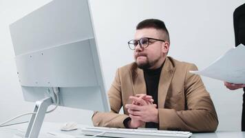 The secretary brings documents to the manager, who is focused on work in a modern office. The concept is to show moments of productive work and process organization in a dynamic business environment video