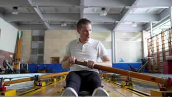 Athlete man pushing limits, training on rowing simulator, enhance technique and power for race video