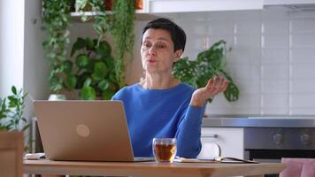 Experienced woman teacher gesturing and explaining assignments via call on laptop for students video