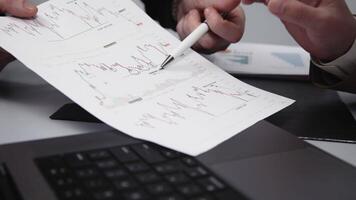 Teamwork of two employees working and entering data on a laptop, reviewing and verifying chart analytics video