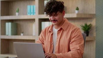 Computer work in office Caucasian man guy male businessman business entrepreneur designer working typing laptop online studying at desk smiling happy employer using pc search data internet e-commerce video