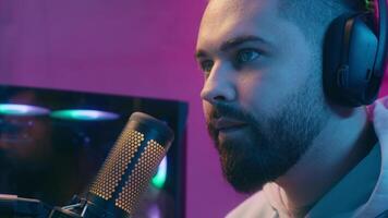 Caucasian addicted male guy man streamer play at computer sad upset internet virtual gaming at home web battle online game talking microphone in headphones dissatisfied problem failure at night video