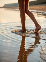 Walking barefoot along the shoreline at sunset with soft waves lapping at the feet photo