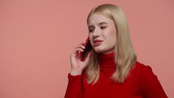 Smiling woman talking on phone call on pink background video