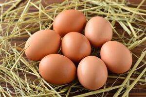 Fresh brown eggs arranged on straw in a rustic setting photo