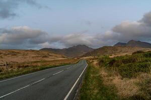 Scenic Road Leading to Snowdonia Mountains at Dusk photo