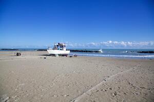 Moored boat on an empty beach in winter photo