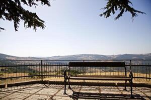 Bench on a panoramic terrace with hills in the background photo